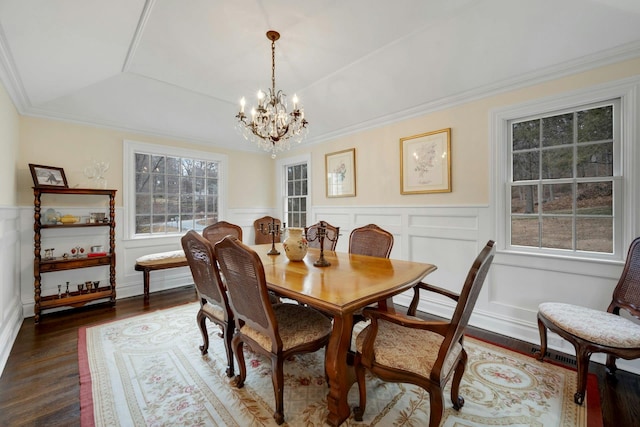 dining space featuring a healthy amount of sunlight, wood finished floors, and wainscoting