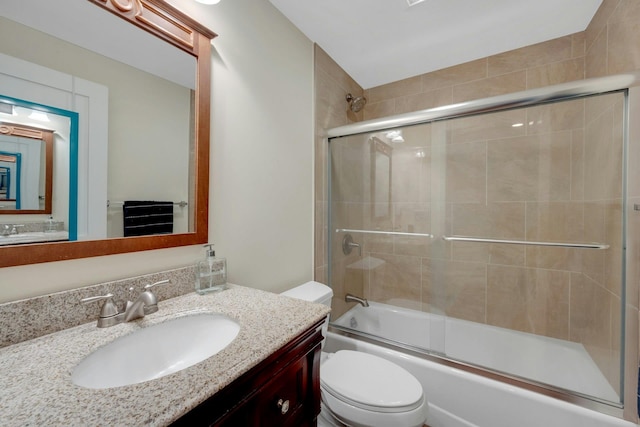 bathroom featuring enclosed tub / shower combo, vanity, and toilet