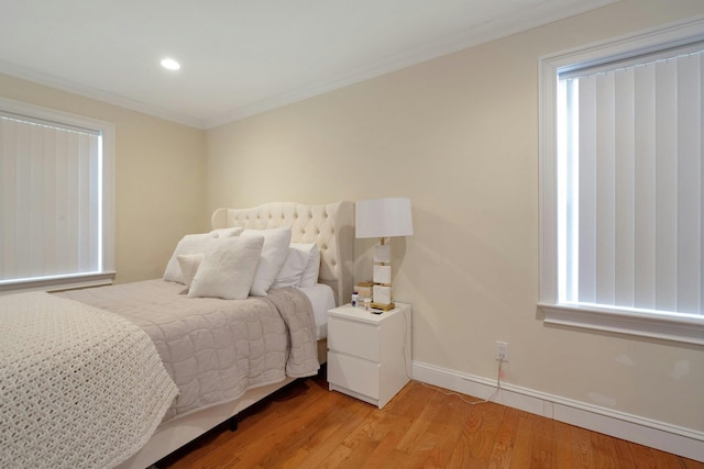 bedroom featuring light wood-type flooring, baseboards, crown molding, and recessed lighting