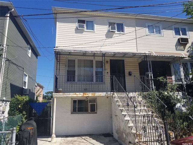 multi unit property with covered porch, stairway, and stucco siding