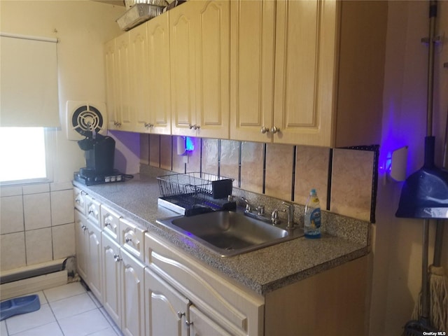 kitchen with tasteful backsplash, light tile patterned flooring, and a sink