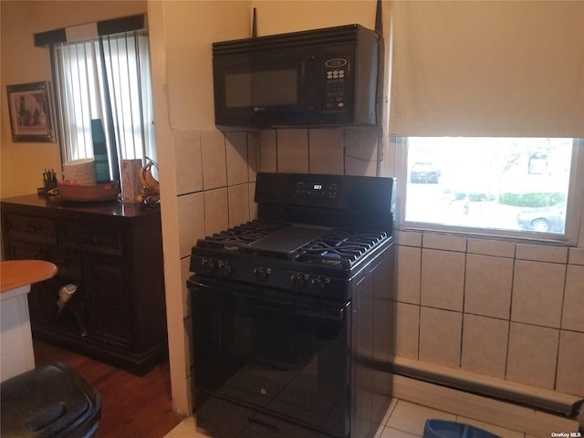 kitchen with black appliances and tasteful backsplash