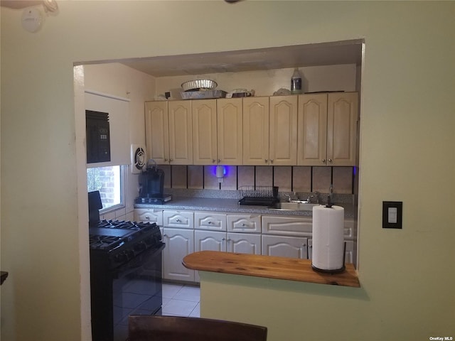 kitchen with light tile patterned floors, wooden counters, decorative backsplash, a sink, and black appliances