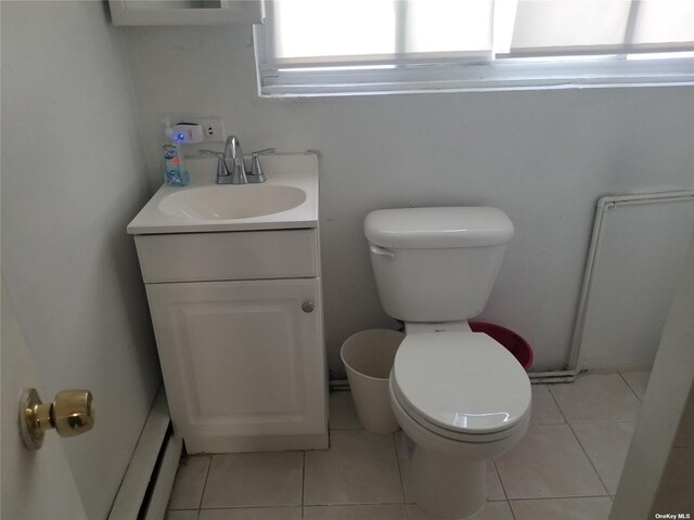 bathroom with toilet, vanity, and tile patterned floors