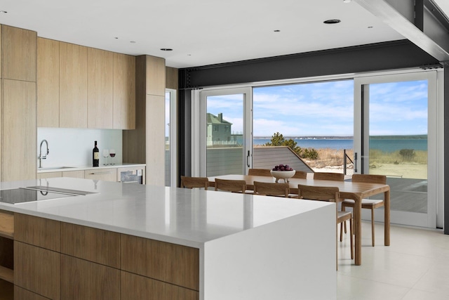 kitchen with black electric cooktop, light countertops, a sink, and modern cabinets