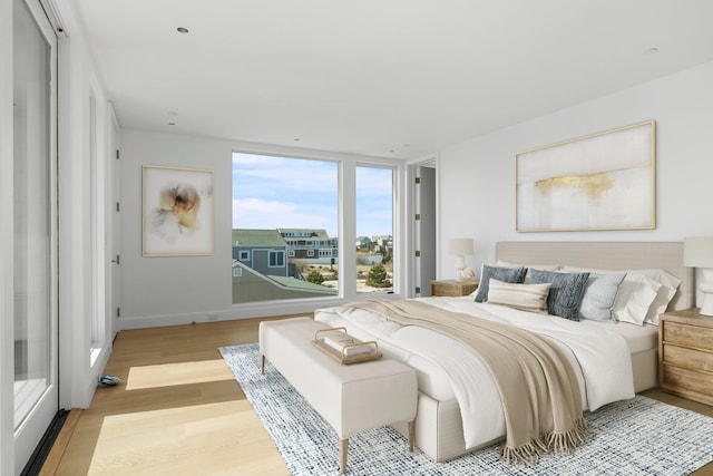 bedroom featuring light wood-style floors, baseboards, and access to exterior