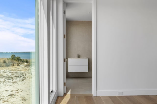 hallway featuring a water view and wood finished floors