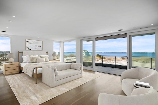 bedroom featuring access to exterior, a wall of windows, wood finished floors, and recessed lighting