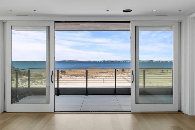 doorway to outside featuring a water view and wood finished floors