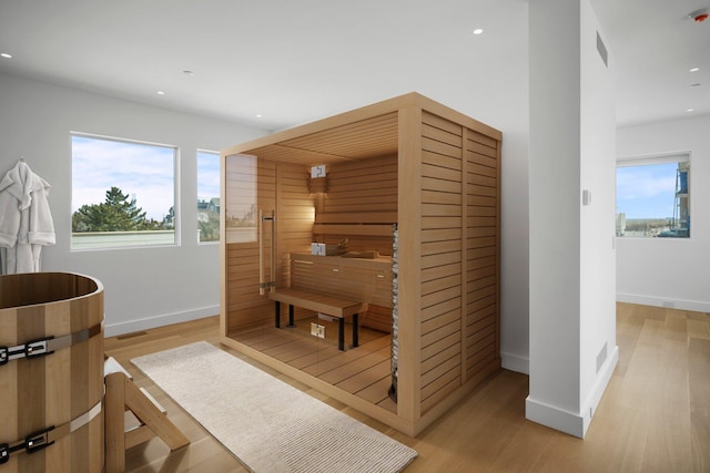 view of sauna featuring recessed lighting, plenty of natural light, baseboards, and wood finished floors