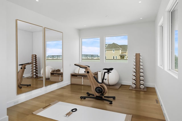 workout room featuring recessed lighting, baseboards, and wood finished floors