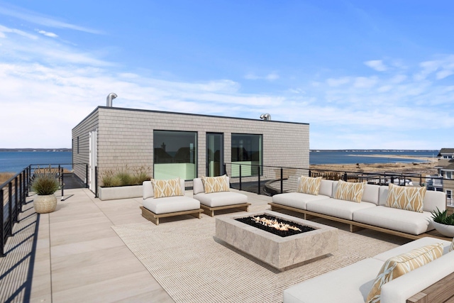 view of patio / terrace featuring a water view, an outdoor living space with a fire pit, and a balcony