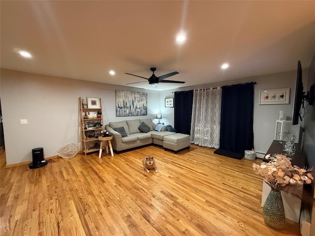 living room with light wood-style floors, recessed lighting, baseboard heating, and a ceiling fan