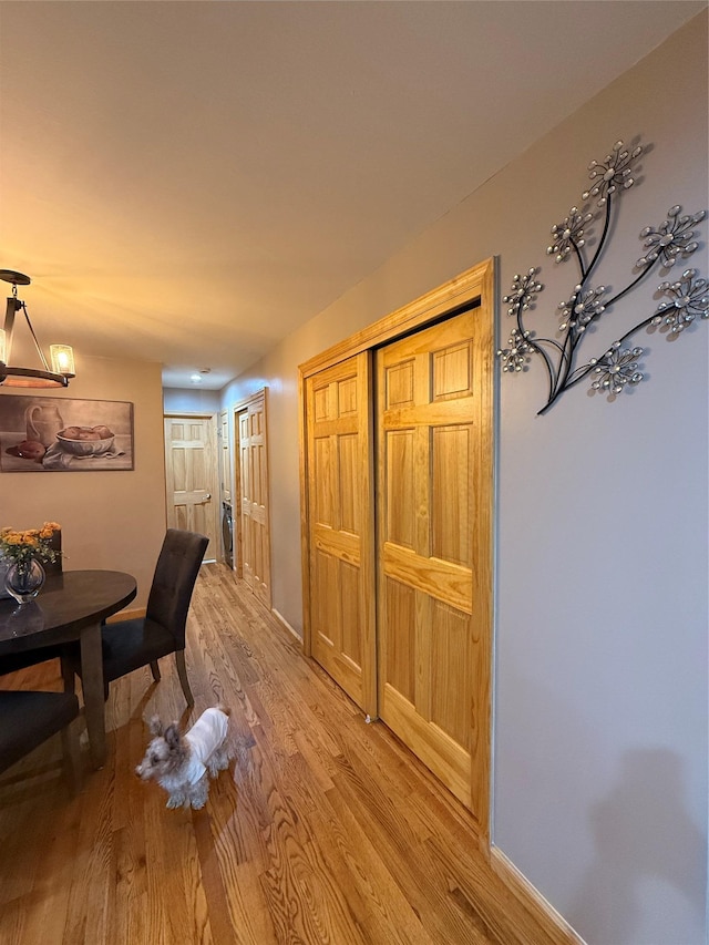 hallway featuring light wood-type flooring and baseboards