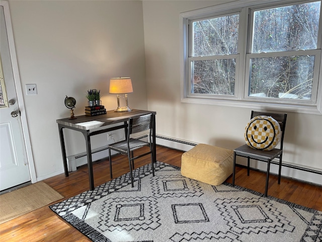 office area featuring baseboards, a baseboard heating unit, and wood finished floors