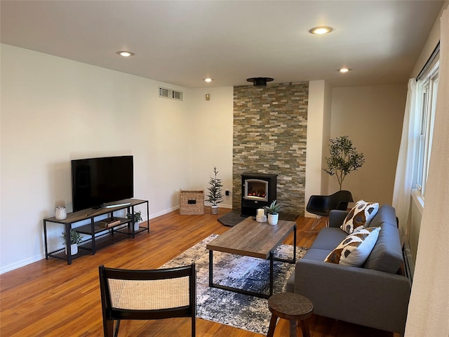 living area featuring baseboards, visible vents, wood finished floors, and recessed lighting