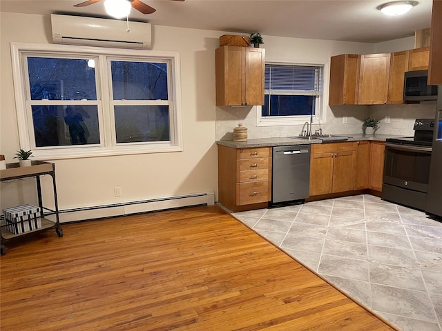 kitchen featuring appliances with stainless steel finishes, a wall mounted air conditioner, a sink, and light wood-style floors