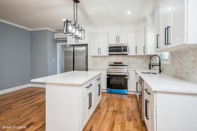 kitchen with light wood-style floors, ornamental molding, stainless steel appliances, and a sink