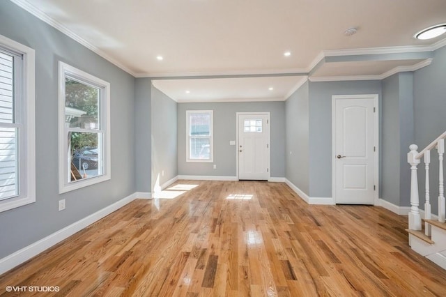 entryway with light wood-type flooring, stairs, baseboards, and ornamental molding