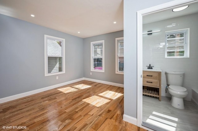 interior space featuring toilet, baseboards, wood finished floors, and recessed lighting