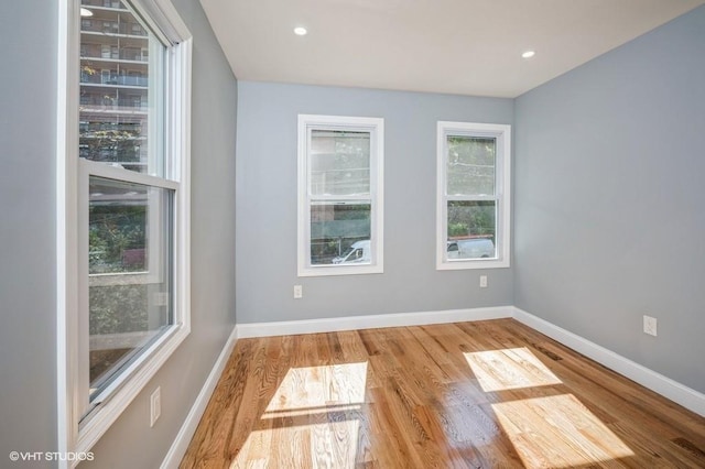 unfurnished room featuring recessed lighting, baseboards, and wood finished floors