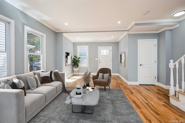 living area with light wood finished floors, baseboards, crown molding, and stairs