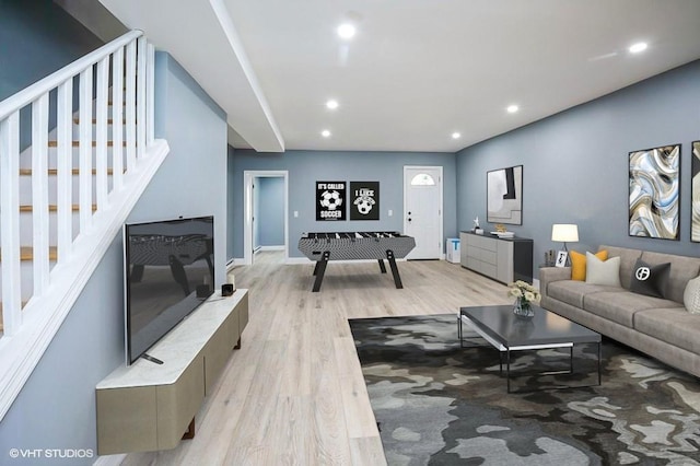 living area featuring light wood-style floors, baseboards, stairway, and recessed lighting