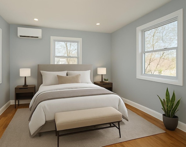bedroom with baseboards, recessed lighting, wood finished floors, and an AC wall unit