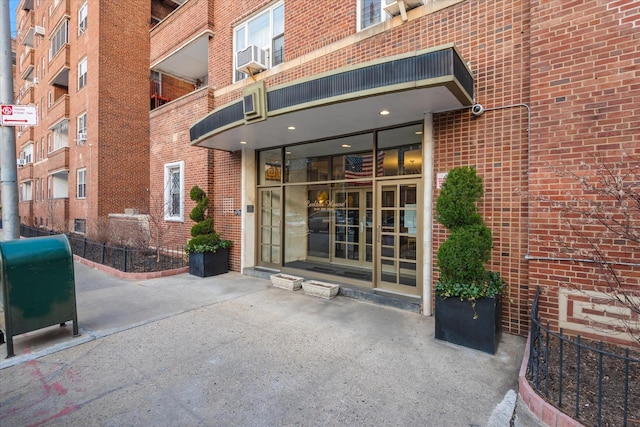 entrance to property featuring french doors, brick siding, and heating fuel