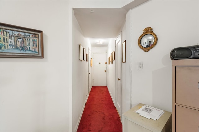 corridor with baseboards and carpet flooring