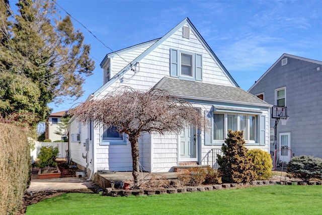 bungalow-style house with a shingled roof and a front yard