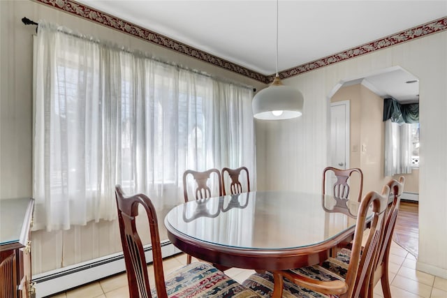 dining room with plenty of natural light, light tile patterned flooring, and arched walkways