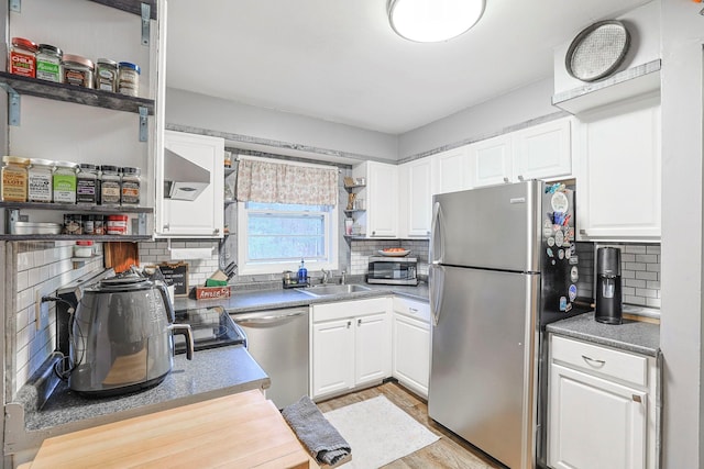 kitchen with open shelves, a sink, white cabinets, and stainless steel appliances