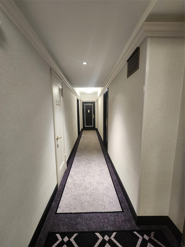 hallway featuring baseboards, visible vents, and crown molding