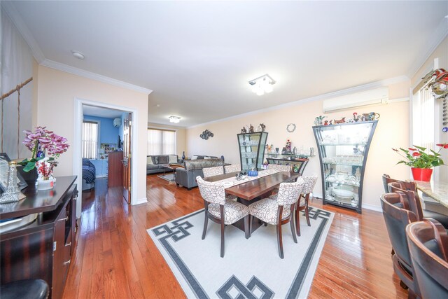 dining space with baseboards, light wood-style flooring, crown molding, and a wall mounted AC