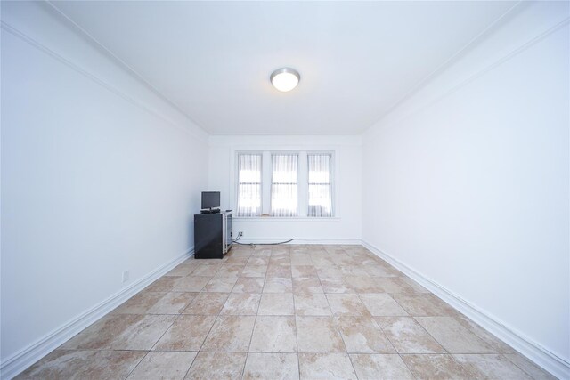 spare room featuring light tile patterned floors and baseboards