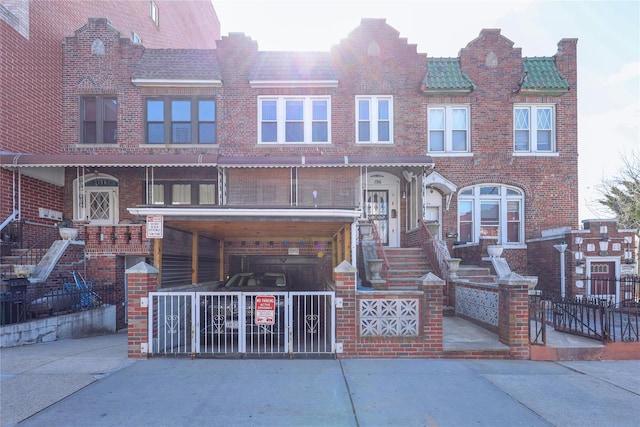 view of front of house featuring concrete driveway, a tiled roof, and brick siding