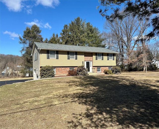 split foyer home with brick siding and a front yard