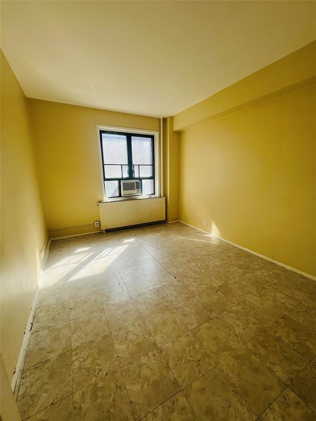 spare room featuring cooling unit and baseboards