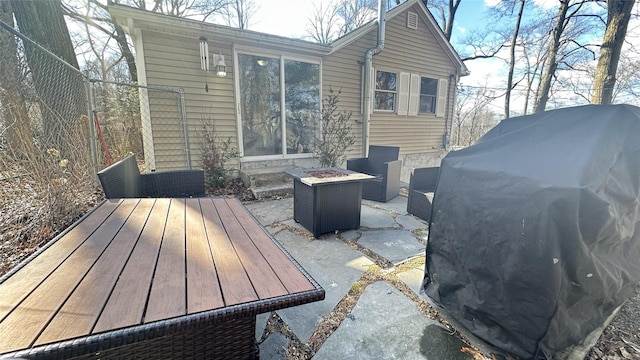 exterior space featuring an outdoor fire pit and a grill