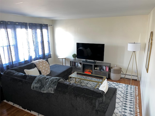 living area with a baseboard heating unit and wood finished floors