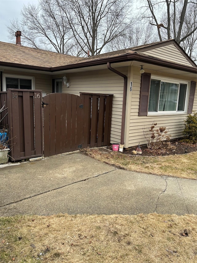 view of side of home featuring an attached garage, a gate, and fence