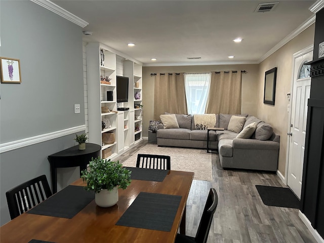 living area with ornamental molding, wood finished floors, visible vents, and recessed lighting