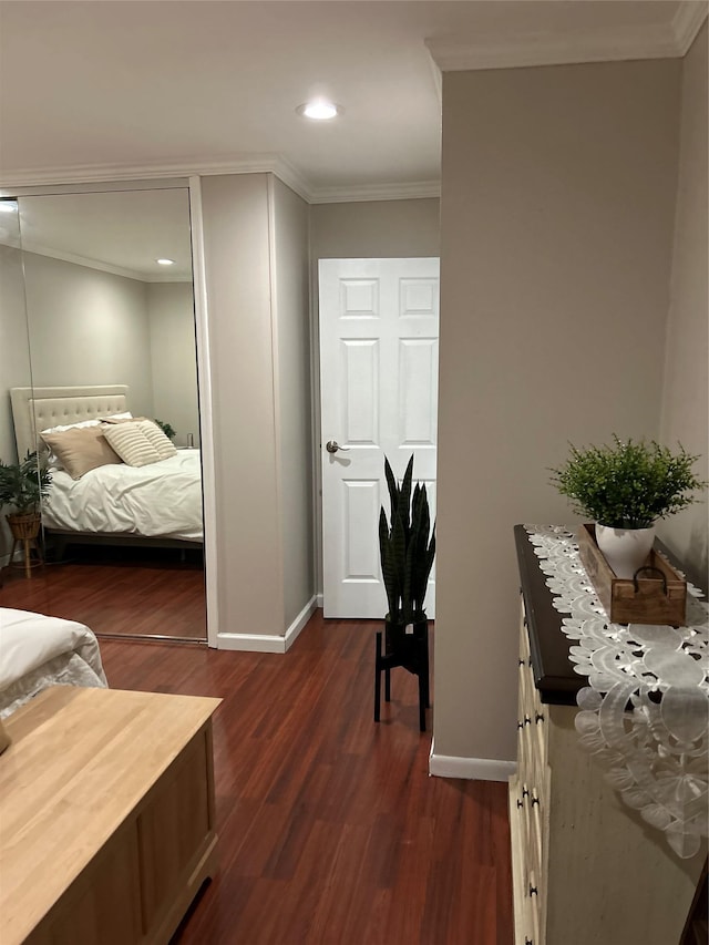 bedroom with dark wood-style floors, baseboards, and crown molding