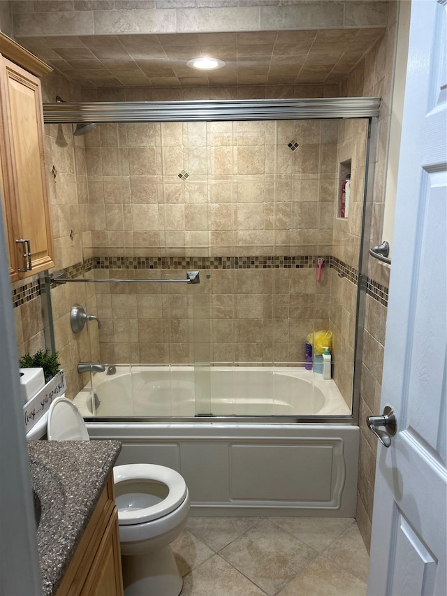 full bathroom with tile patterned flooring, combined bath / shower with glass door, vanity, and toilet