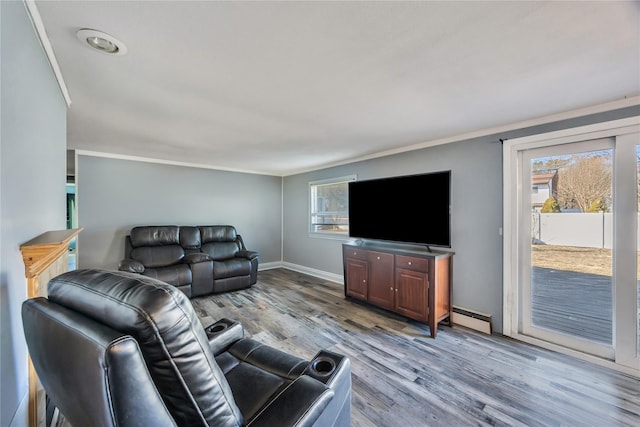 living area with crown molding, light wood-style floors, baseboards, and baseboard heating