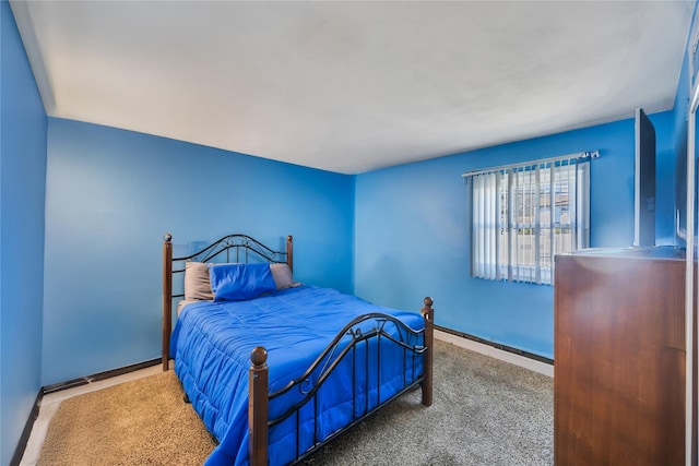 carpeted bedroom featuring a baseboard heating unit and baseboards