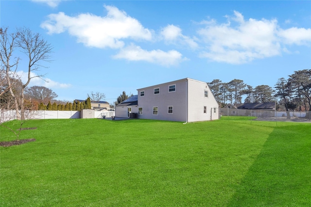 back of property with a lawn and a fenced backyard