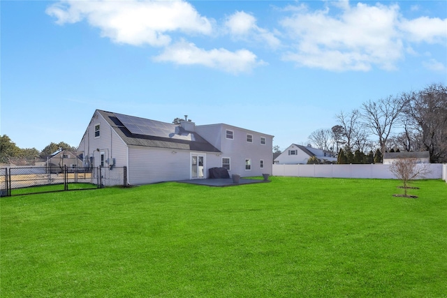 rear view of property featuring a gate, a lawn, a fenced backyard, and a patio area