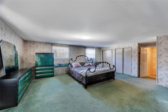 bedroom with carpet floors, two closets, and wallpapered walls